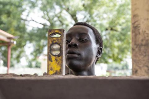 Student, Magen*, 20, checks the levels in his masonry class at Save the Children’s vocational training centre in South Sudan